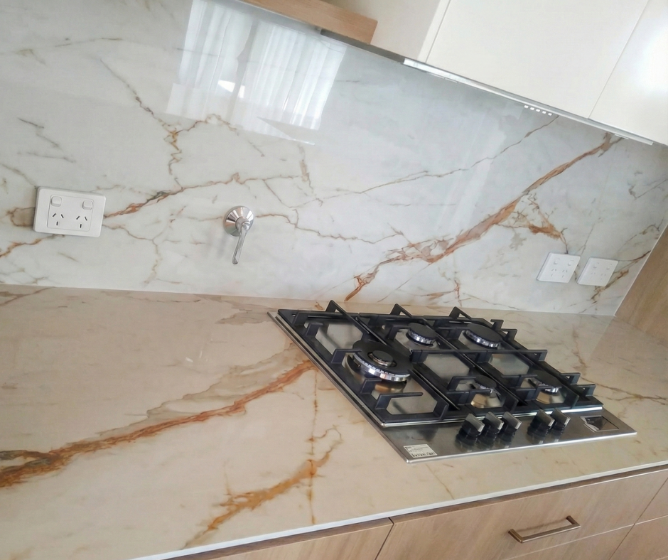 Mesada y frente de cocina en piedra clara con vetas doradas